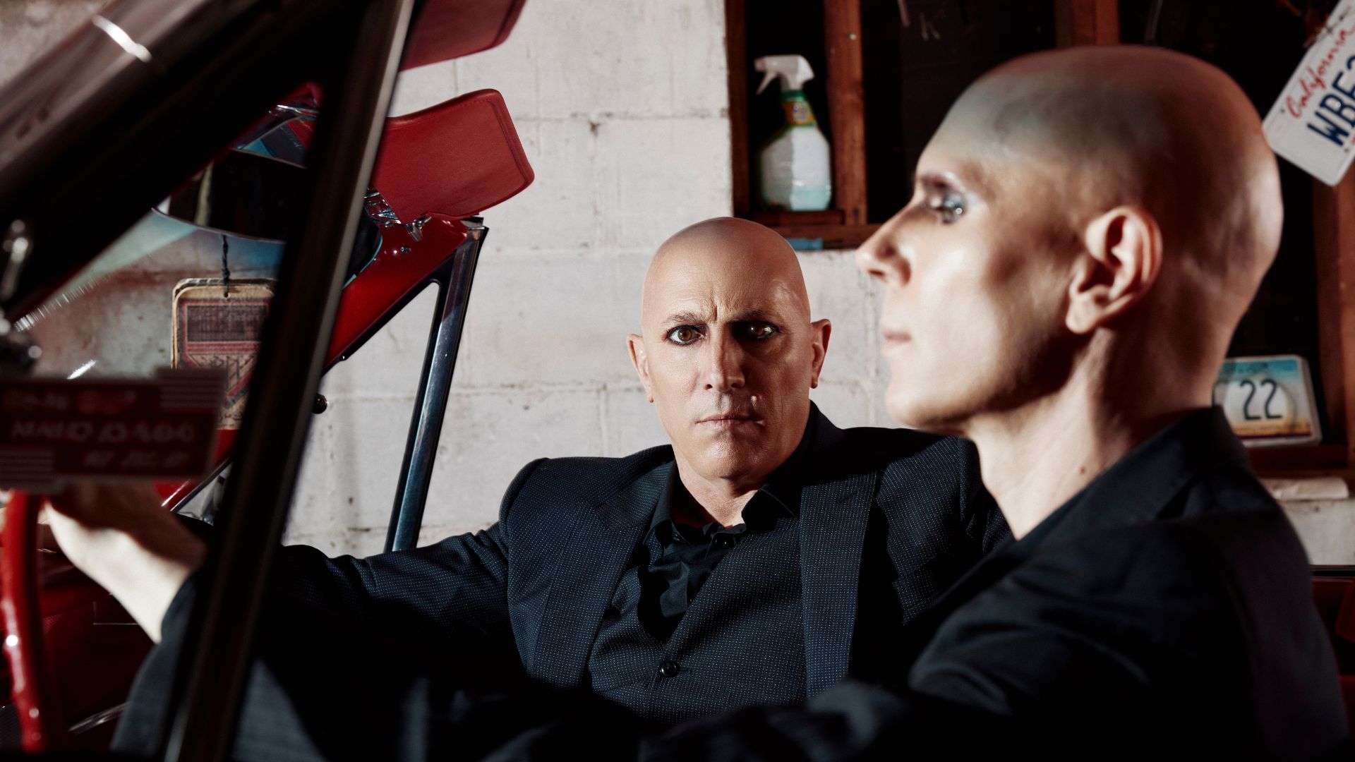 Billy Howerdel photographed beside a mannequin inside a car.