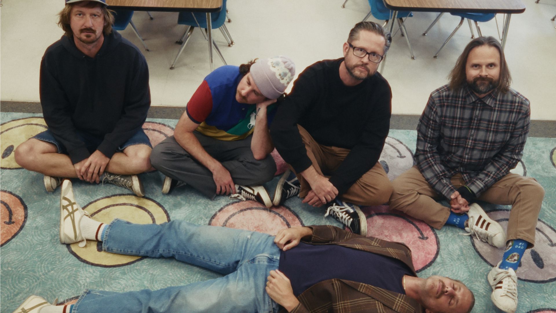 The Barbarians of California sit together on a patterned classroom rug.