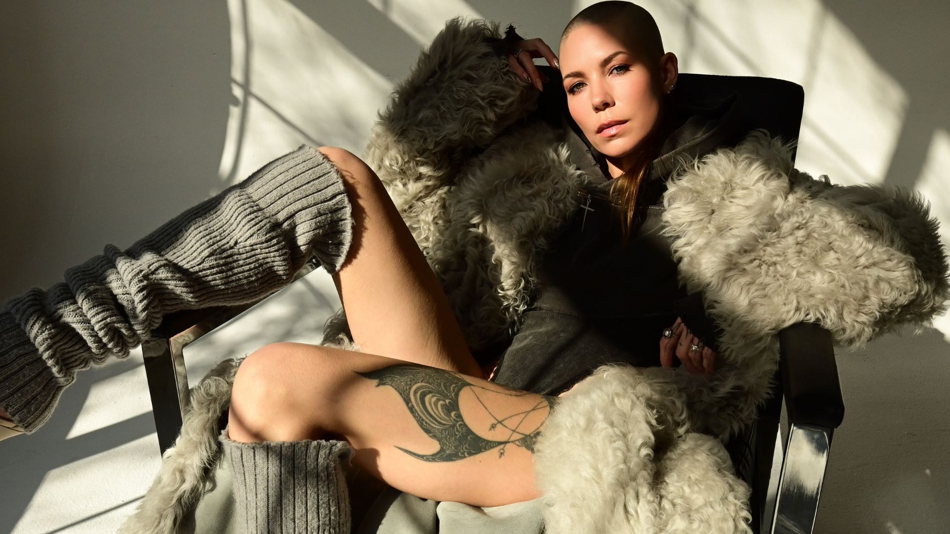 Skylar Grey sits in direct sunlight wearing a shearling coat.