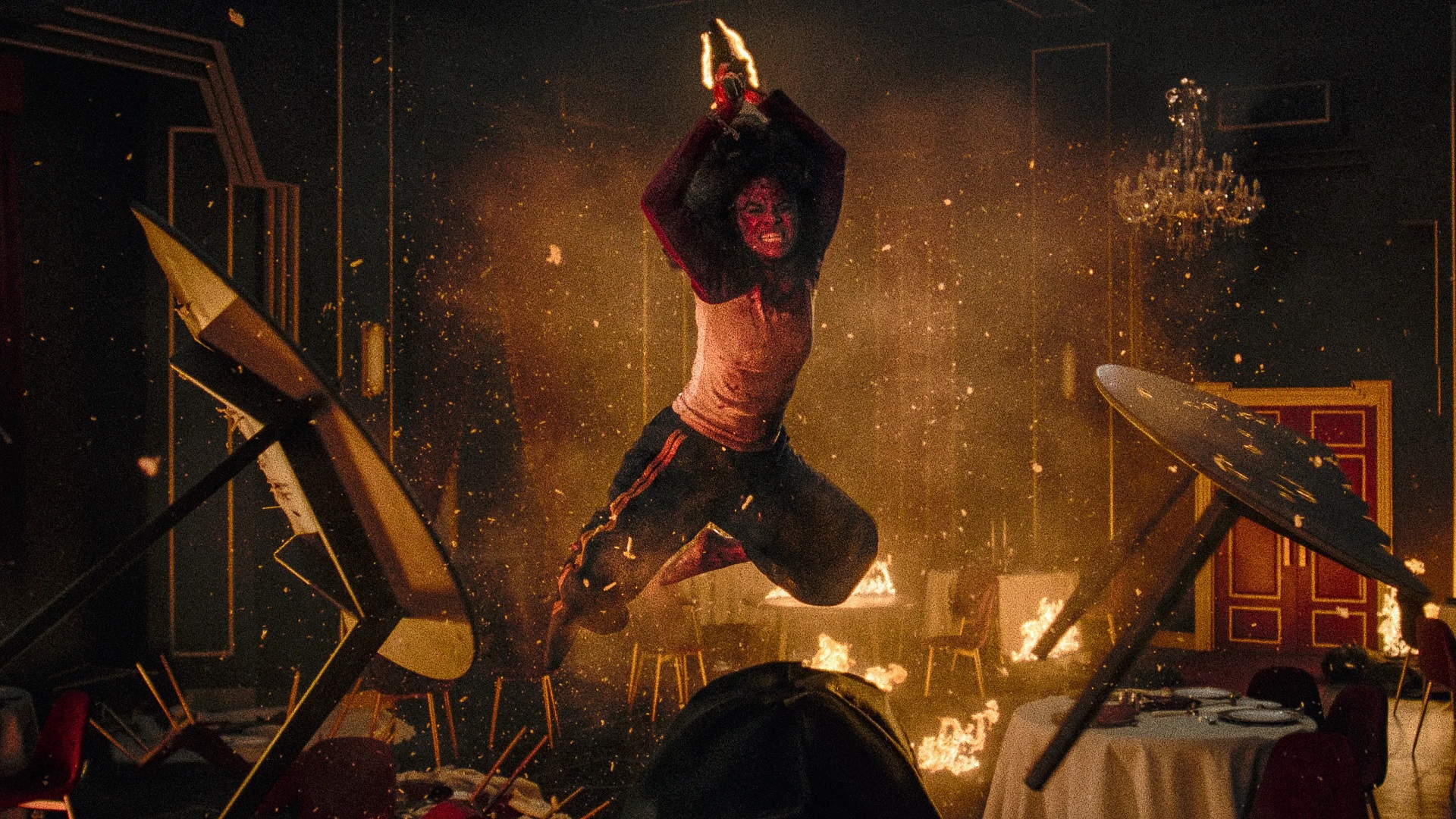 Zazie Beetz leaps through a burning dining room in They Will Kill You.